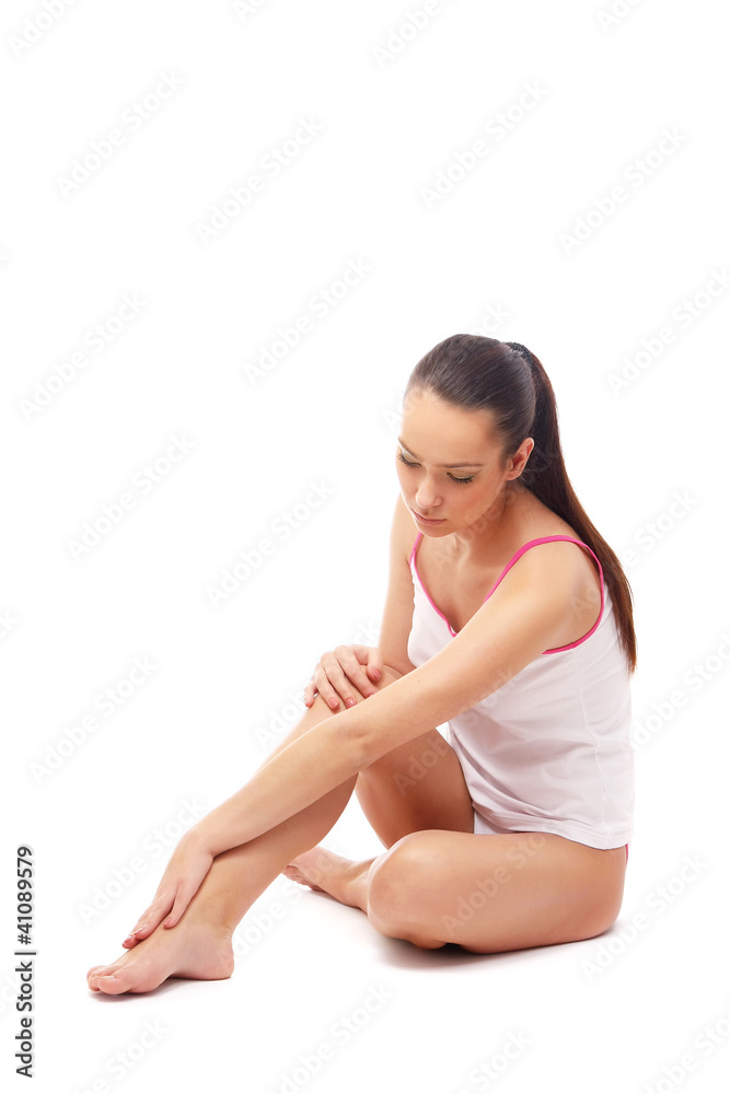 A beautiful woman applying cream on her legs A beautiful woman applying cream on her legs