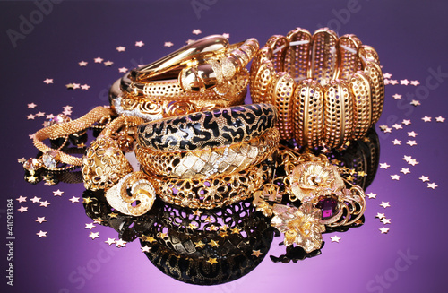 Beautiful golden jewelry on purple background