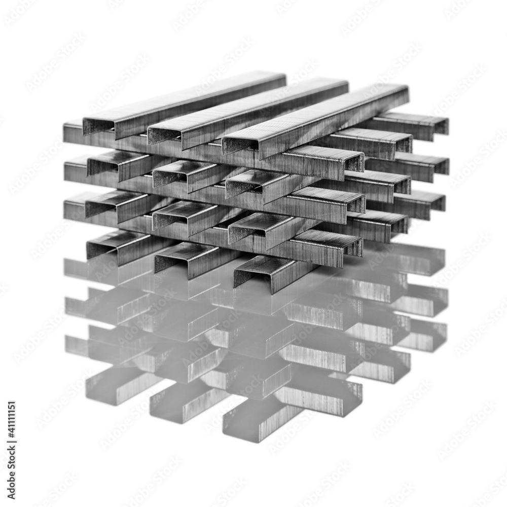 Stacks of staples on a reflective surface Stacks of staples on a reflective surface