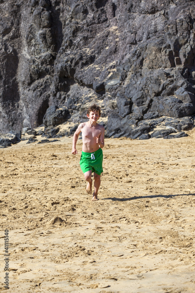 boy is running on the beach on a sunny day