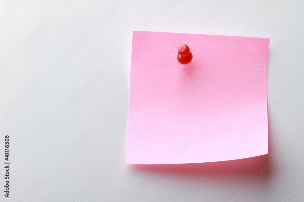 A pink note paper with a red pin A pink note paper with a red pin