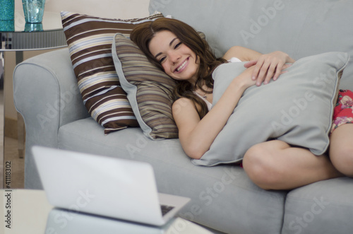 Cute girl watching TV on her laptop