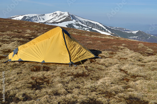 yellow tent upon snowy spring ridges