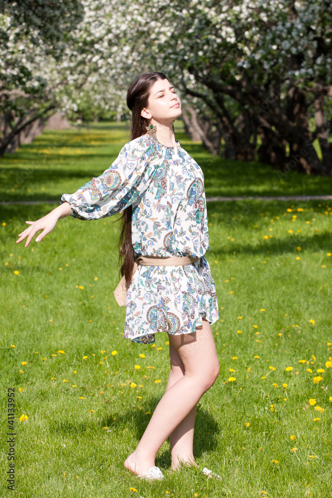 The long-haired girl against blossoming apple-trees.