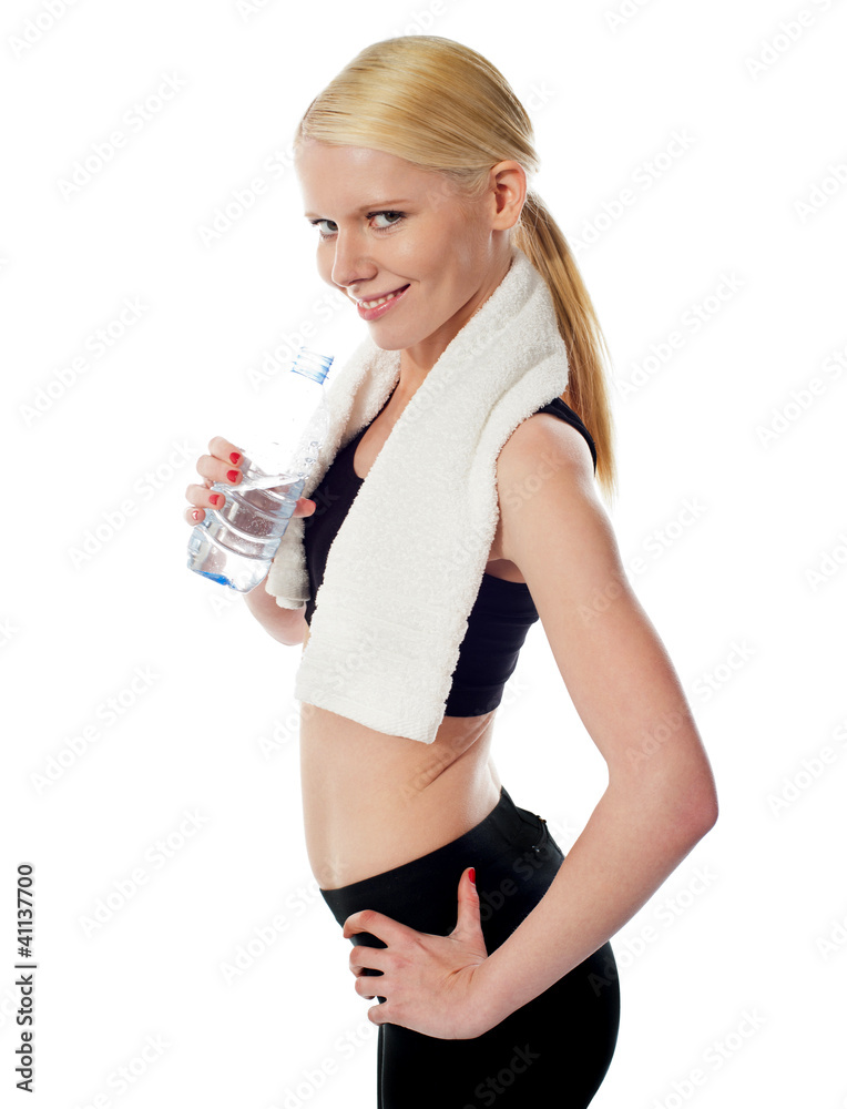 Fit female athlete holding a bottle of water Fit female athlete holding a bottle of water