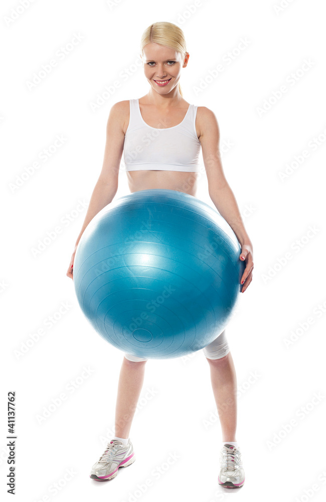 Smiling female athlete holding a big blue ball Smiling female athlete holding a big blue ball