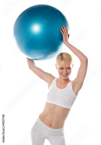 Female athlete holding blue ball, studio shot