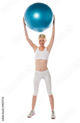 Sporty woman holding ball over her head © stockyimages