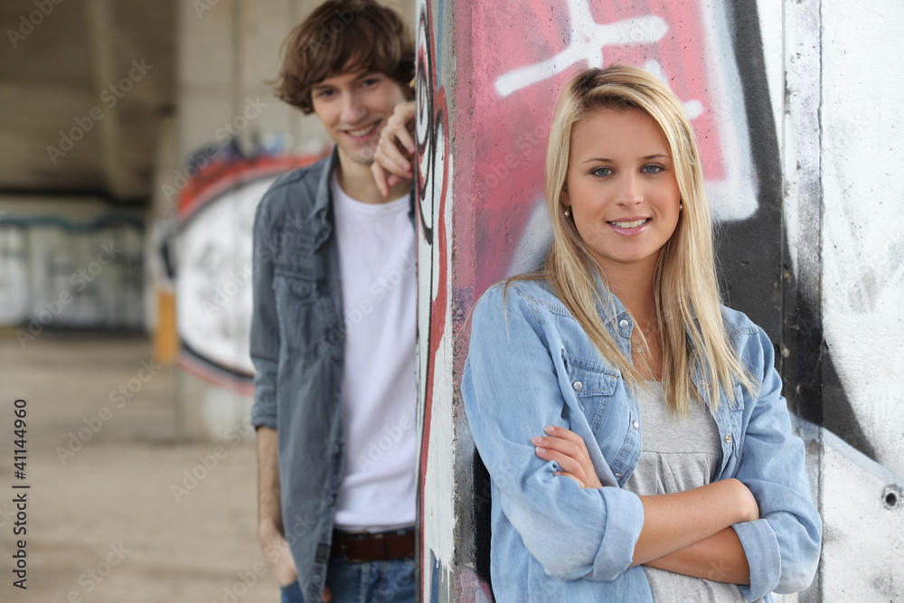 Attractive couples stood by graffiti covered wall Attractive couples stood by graffiti covered wall