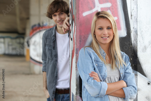 Attractive couples stood by graffiti covered wall