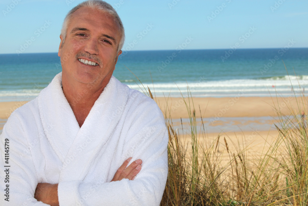 Man in bathrobe on the beach