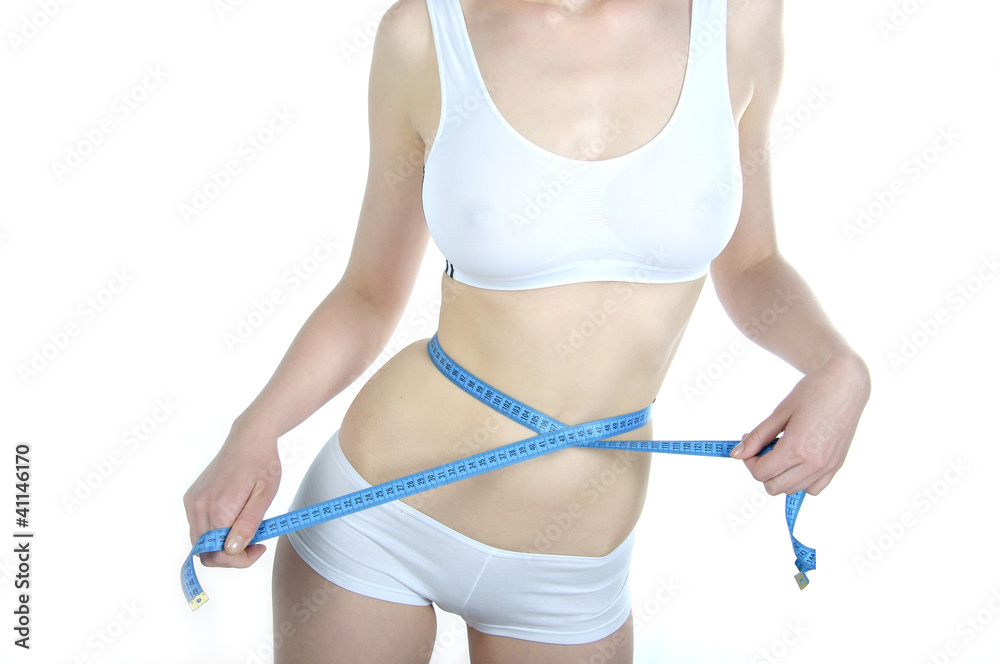 Obraz premium młoda kobieta mierząca talię centymetrem