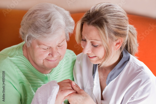 Altenpflegerin wäscht Seniorin die Hände photo