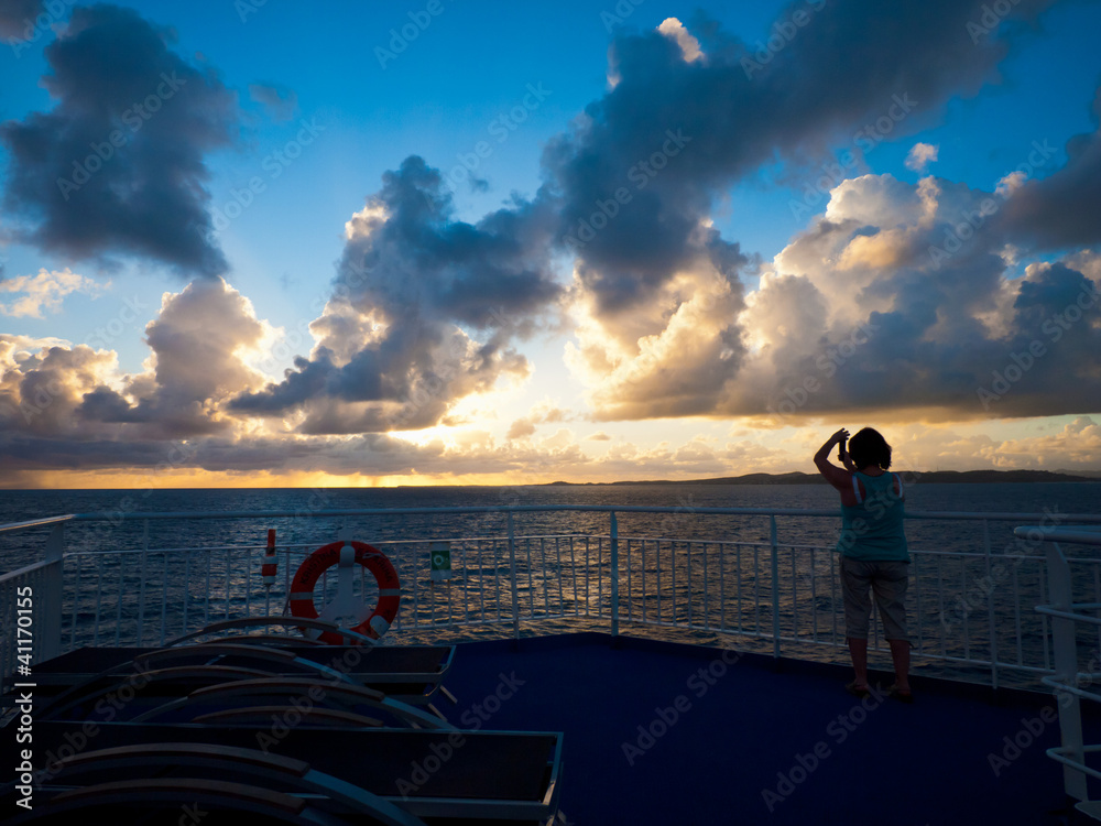 Fototapeta premium woman taking picture of sunrise