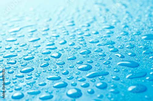 Close-up of fresh water drops on blue surface
