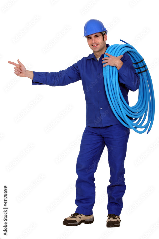 Electrician with cable pointing at copy space Electrician with cable pointing at copy space