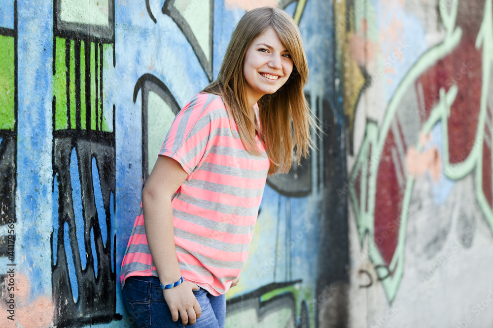 Naklejka premium Style teen girl near graffiti wall.