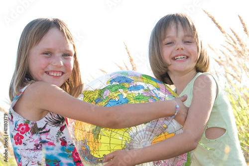 Happy girls holding globe