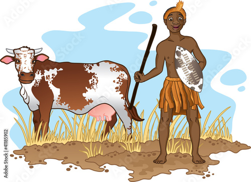 Young African Zulu man in traditional dress  with nguni cow.