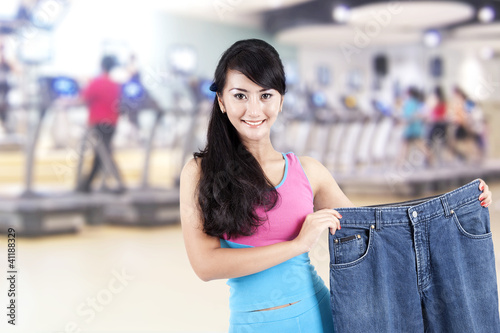 Asian woman loosing weight posing in gym
