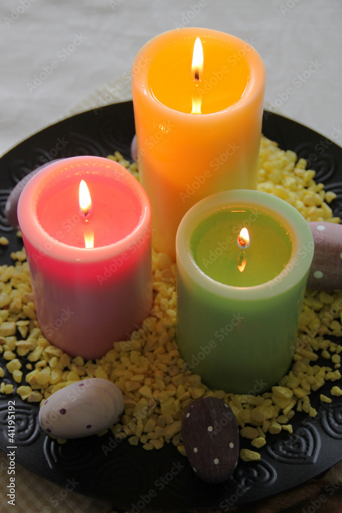 Obraz premium Bunte Kerzen mit gepunkteten Eiern - Hochformat