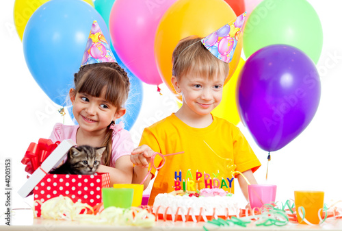 happy children celebrating birthday party with opening gift box