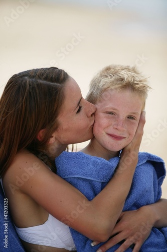 Woman kissing her son on a beach