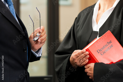 Anwältin mit Gesetzbuch und Mandant photo