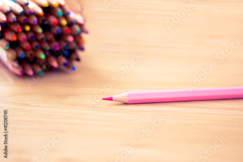 pink pencil in focus and other colors in tbackground photo