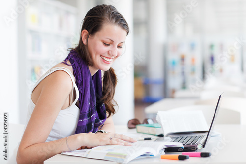 pretty female college student studying in the university library