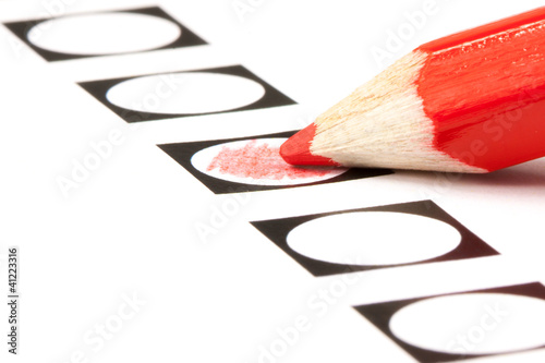 Voting form with red pencil filling in a black circle