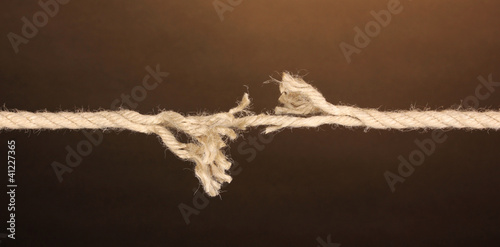Breaking rope on brown background
