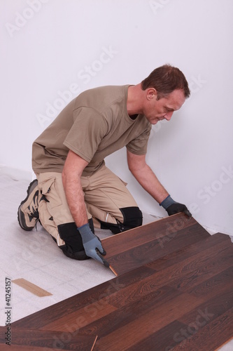 handyman laying floorboards