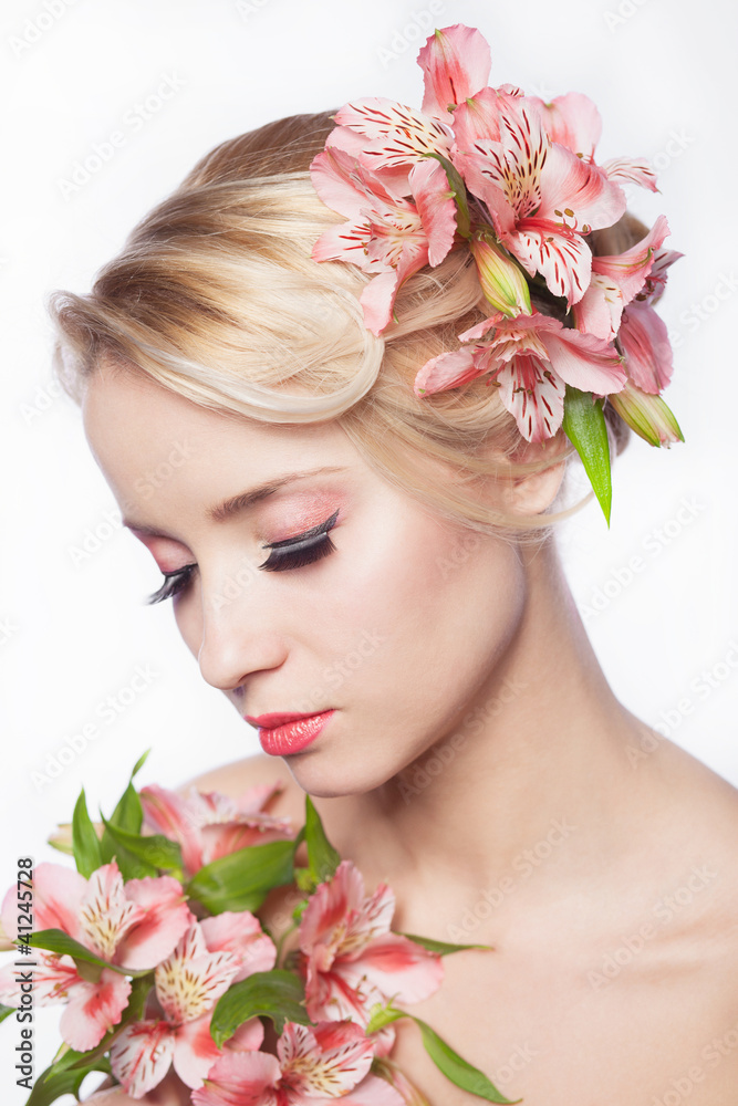 Pretty face of beautiful young woman with lily on hands - white