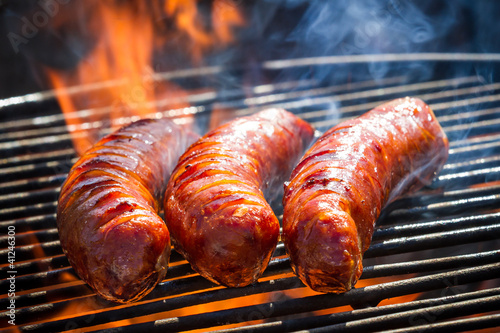 BBQ with fiery sausages on the grill