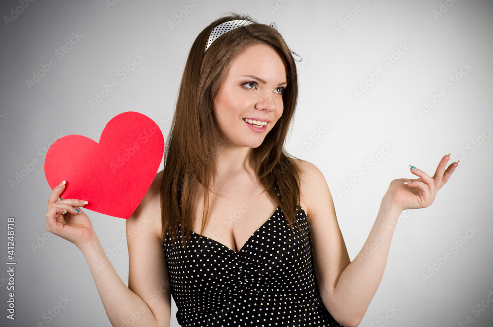 Beautiful young woman with red heart on dark background Beautiful young woman with red heart on dark background