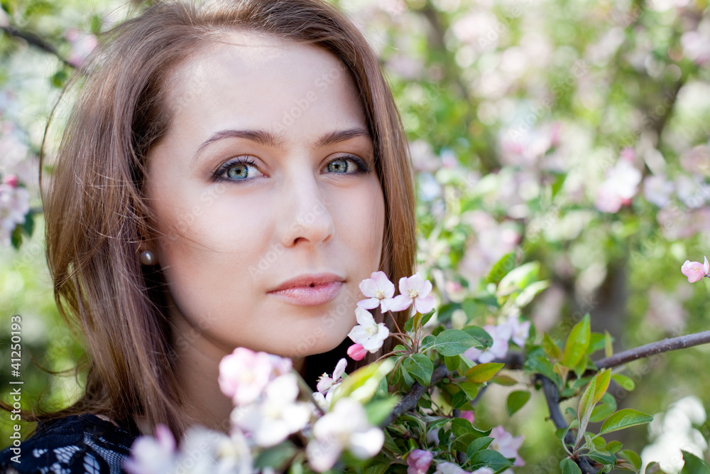 Yong pretty woman in park with blossom tree