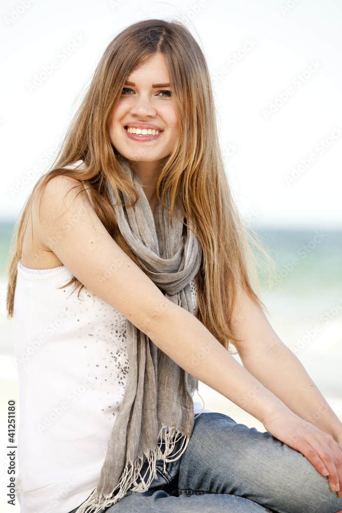 Funny teen girl sitting near the sea. Funny teen girl sitting near the sea.