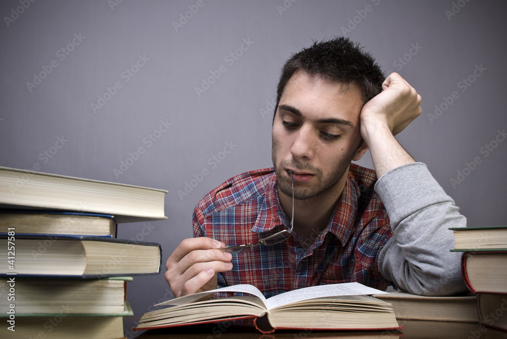 Bored young man reading a book Bored young man reading a book