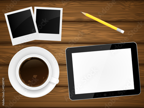 Coffee cup, photo frame and tablet pc on wooden background.