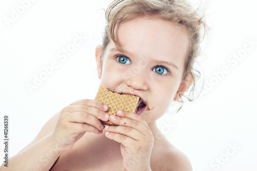 Beautiful sweet  little girl eating a cookie