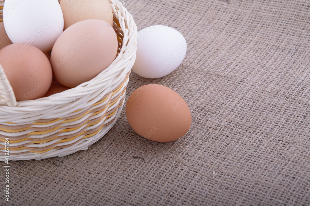Eggs in basket on a sacking background Eggs in basket on a sacking background