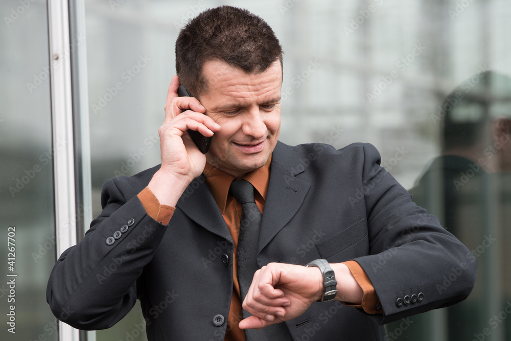manager telefoniert und schaut auf die uhr manager telefoniert und schaut auf die uhr