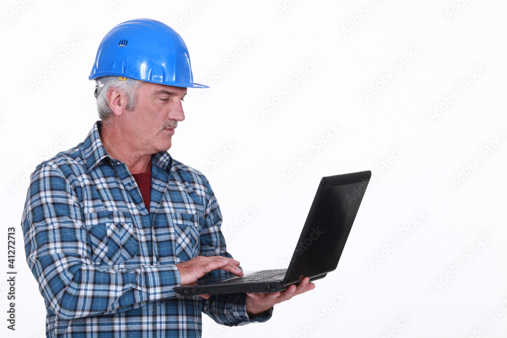 senior craftsman holding a laptop