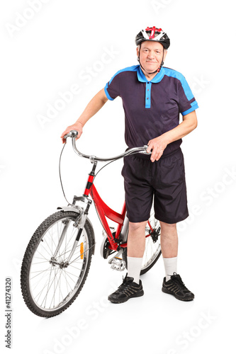 Senior bicyclist posing next to a bicycle