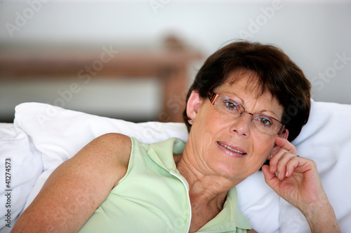 Retired woman propped up against some cushions
