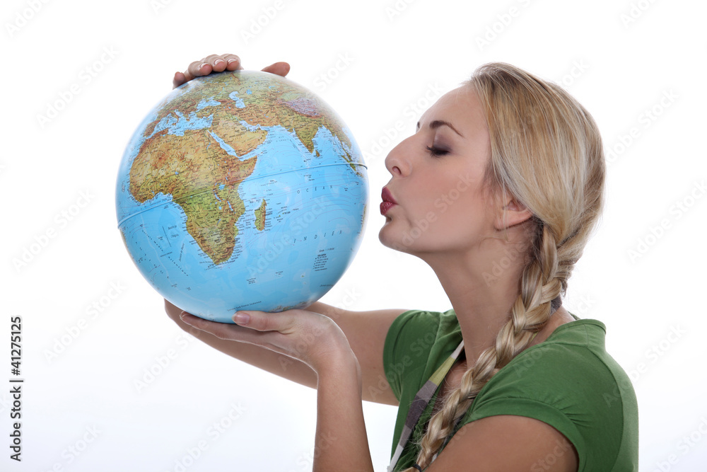 Woman in a green top kissing a globe Woman in a green top kissing a globe