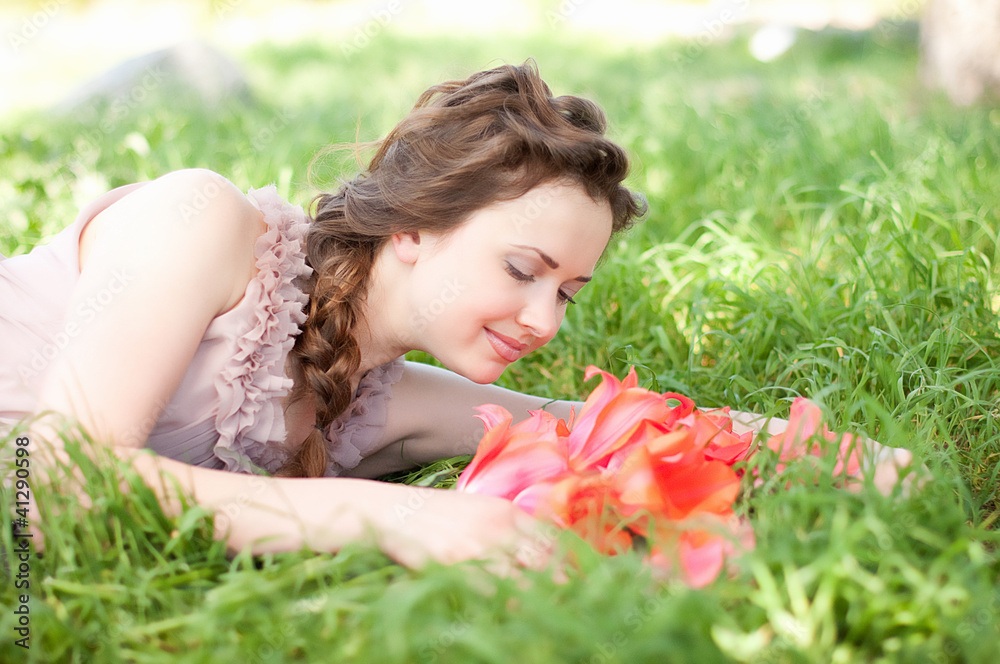 Beautiful woman with red spring tulips in a garden Beautiful woman with red spring tulips in a garden