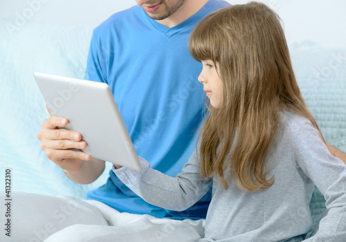 Father and daughter looking at digital tablet © bloomicon