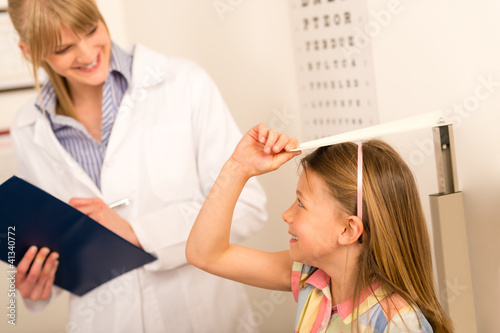 Pediatrician measure height of little girl
